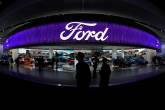 People walk by the Ford display during the North American International Auto Show in Detroit