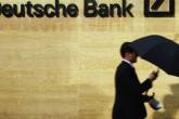 Homem com guarda-chuva passa em frente ao prédio do Deutsche Bank em Londres, na Inglaterra